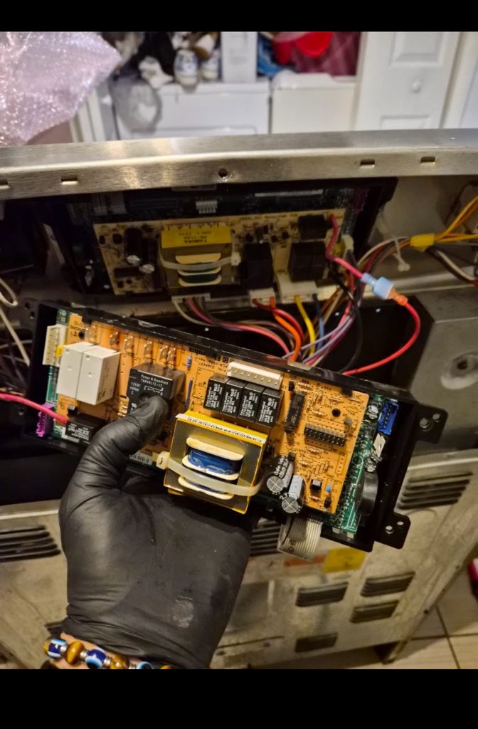 Technician holding a replacement appliance control board
