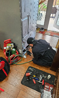 Technician servicing an appliance with tools on site