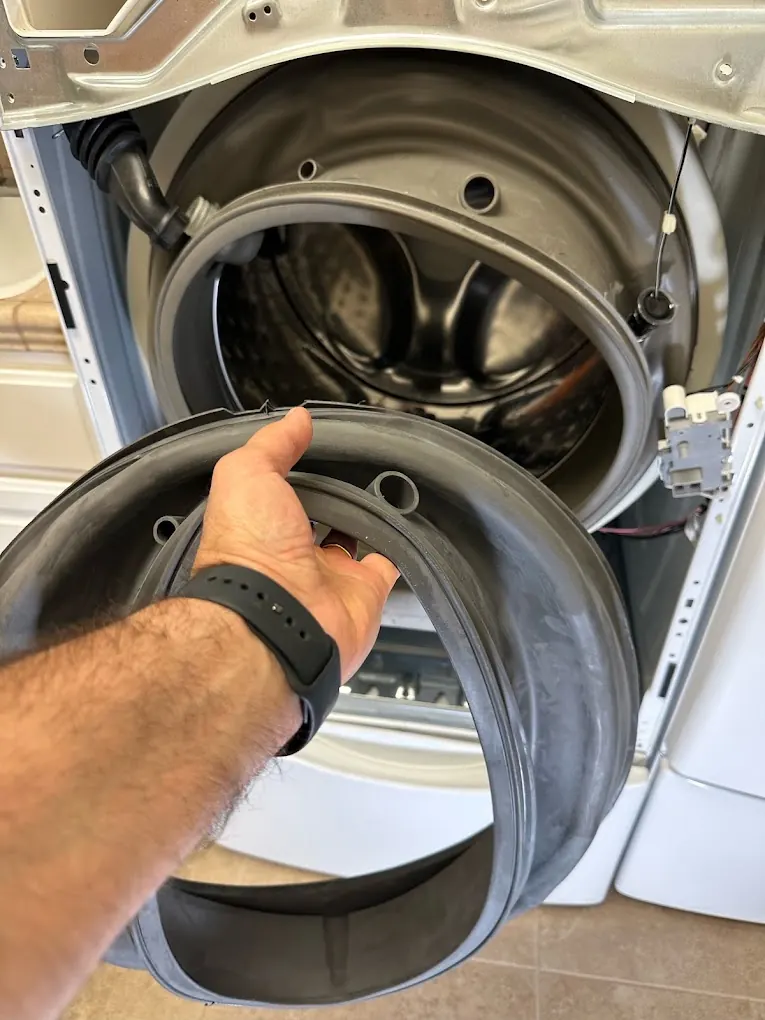 Technician servicing an appliance with tools on site
