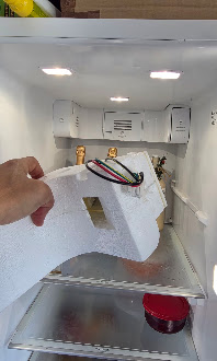Inside view of a refrigerator during component replacement